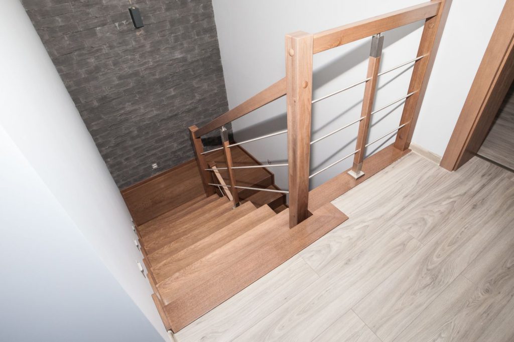 Schody dywanowe dąb-popiel. Balustrada drewno łączone z nierdzewką.Realizacja  Jankowice