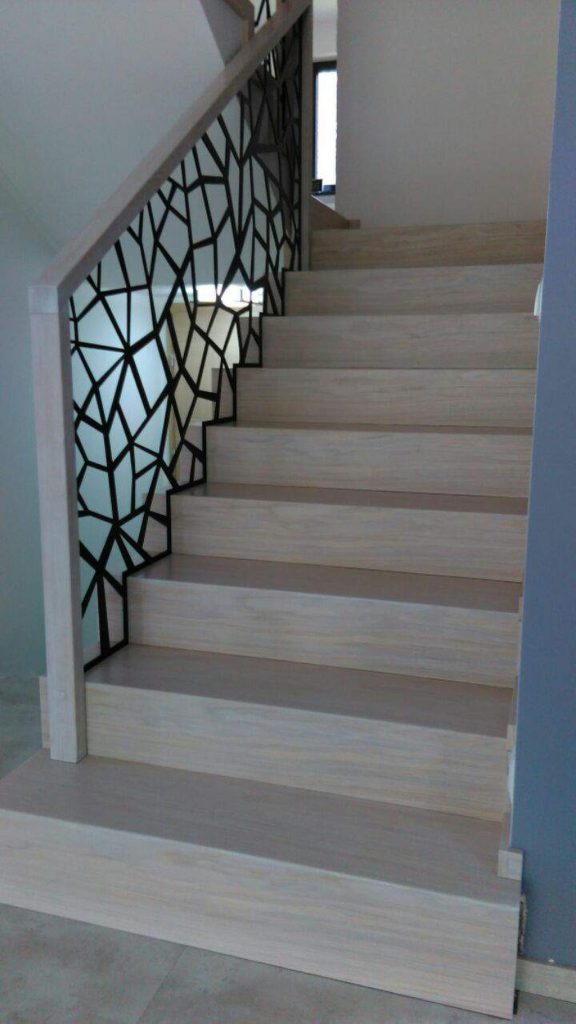 Schody dywanowe bielone. Balustrada wypalana laserowo malowana na czarno. Realizacja Bełsznica