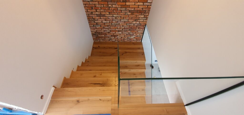 Schody dywanowe dębowe-Rustic. Balustrada szklana. Realizacja Wrocław-Bielany