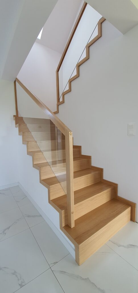 Schody dywanowe dąb natura. Balustrada wypełniona szkłem. Realizacja Żory-Baranowice