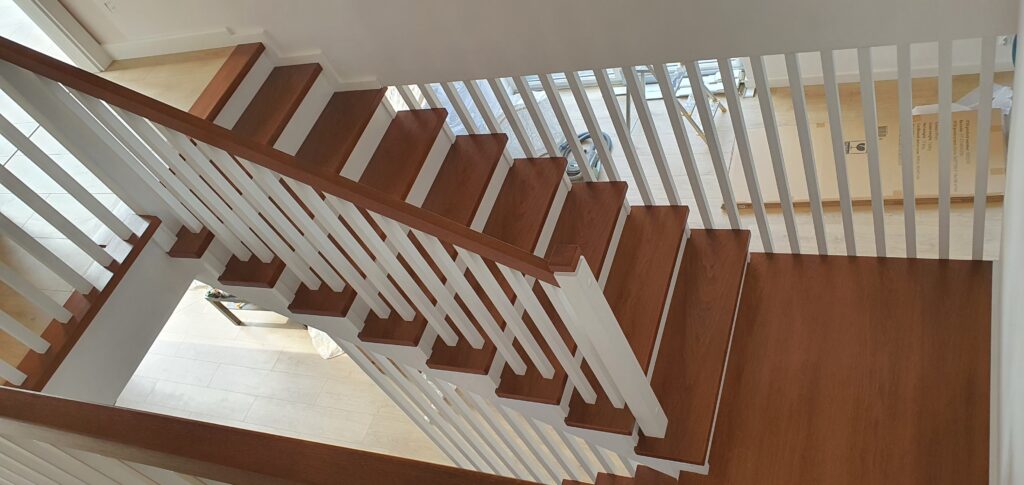 Schody drewniane z białymi podstopnicami oraz Drzwi drewniane lakierowane na biało. Realizacja Dąbrowa Górnicza